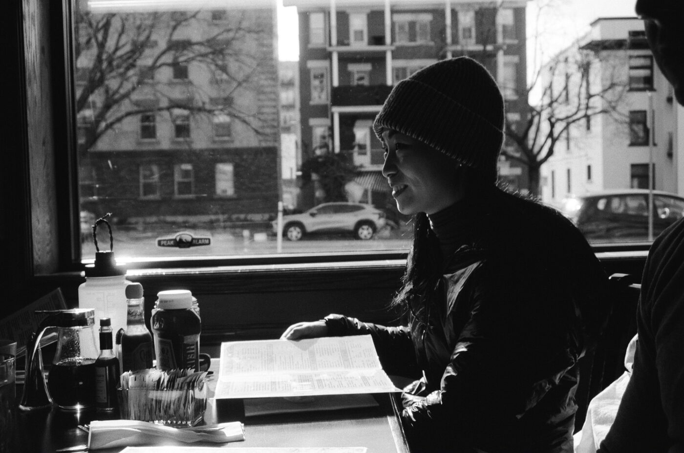 Woman in beanie at a diner window