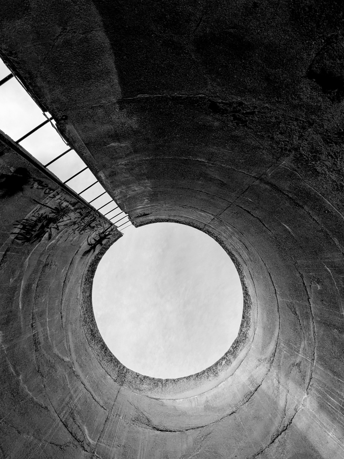 Upward view of concrete silo opening with adjoining structure