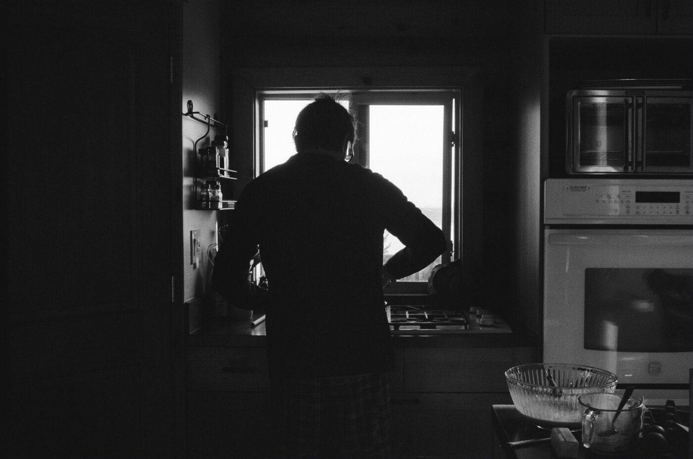 Silhouette of a person at a kitchen window