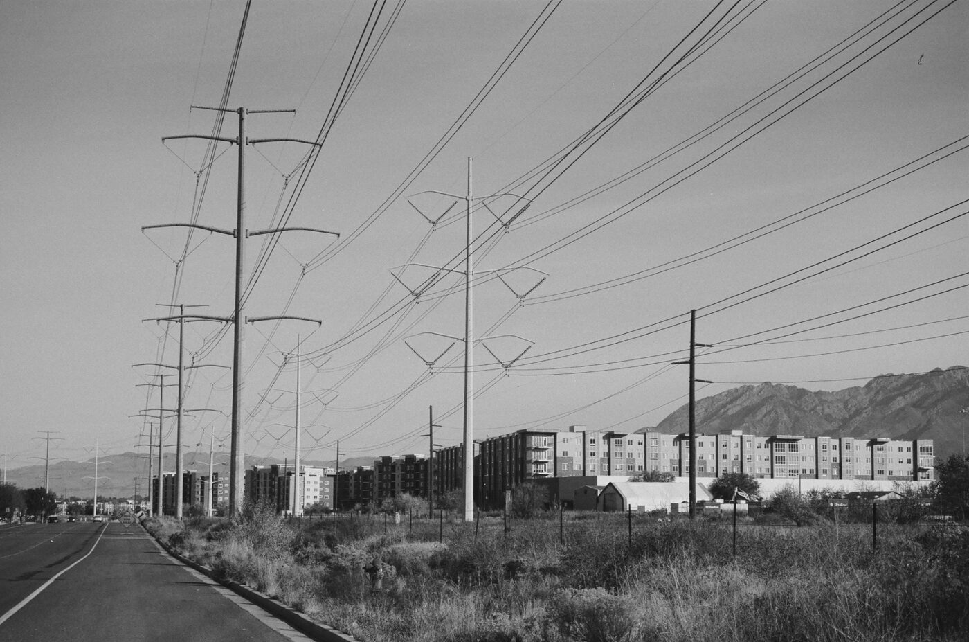 Power lines stretching toward apartments and mountains