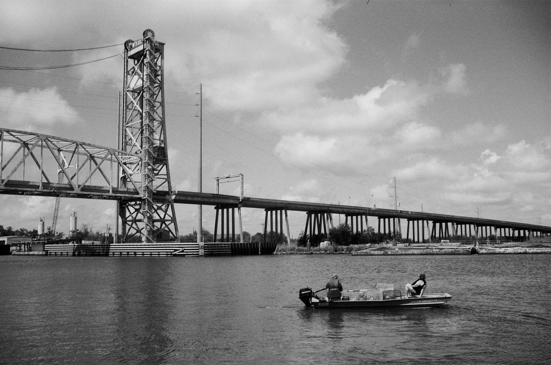 Lift bridge and long highway over the water with a small fishing boat