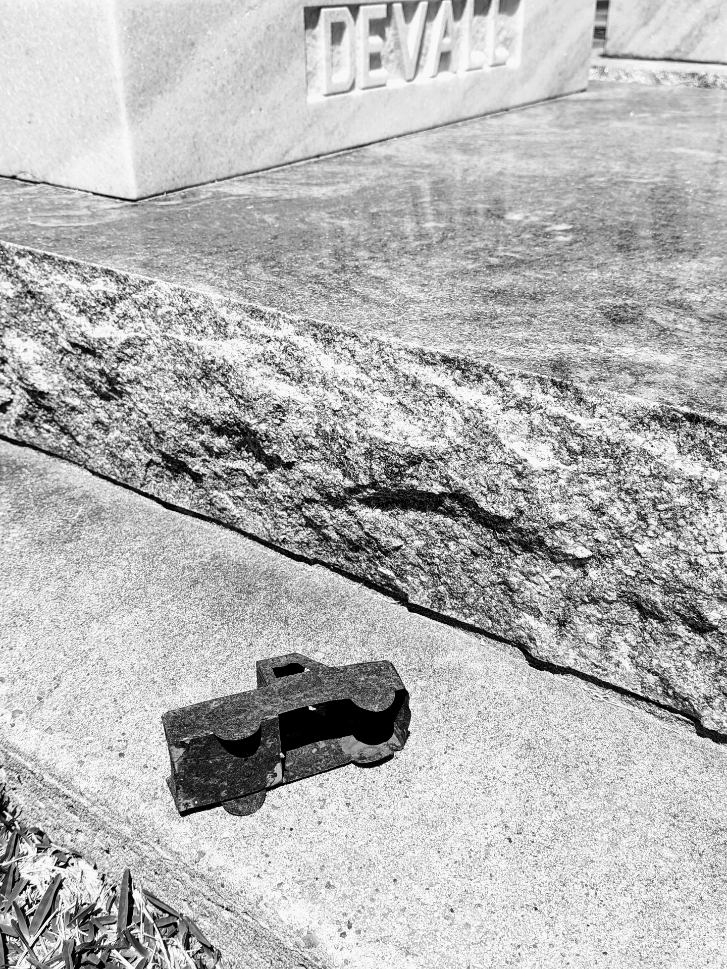 Devall headstone with iron cross fragment on concrete