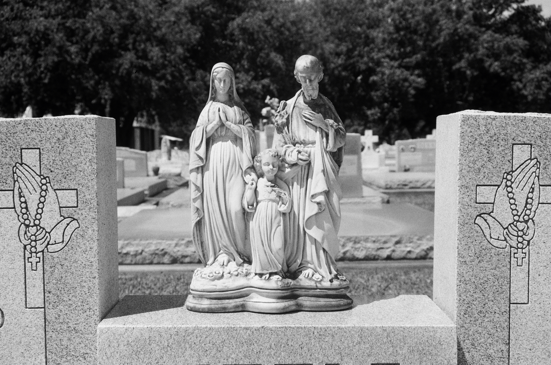 Religious statue centered between grave markers