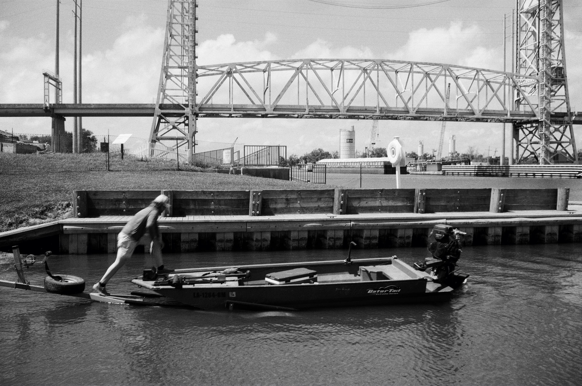 Small boat pulling away from a dock under the bridge